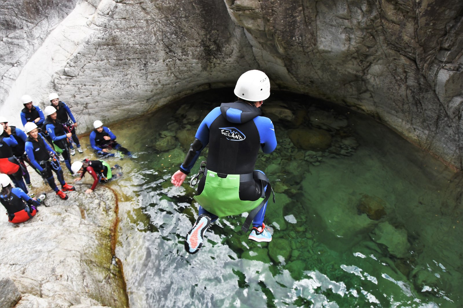 Person jumping into a pool in the Richiusa Canyon