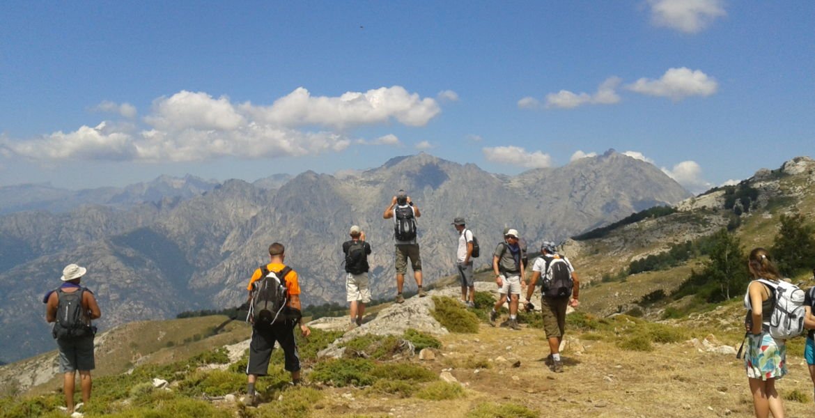 Groupe de randonneurs devant une vue panoramique de la montagne pendant une sortie randonnée encadrée en Corse