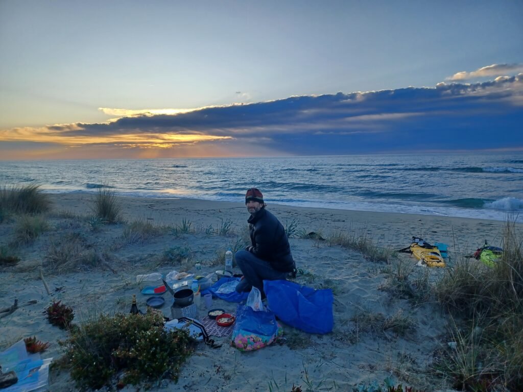 Pat resting on its night camp after a day sea kayaking in Corsica