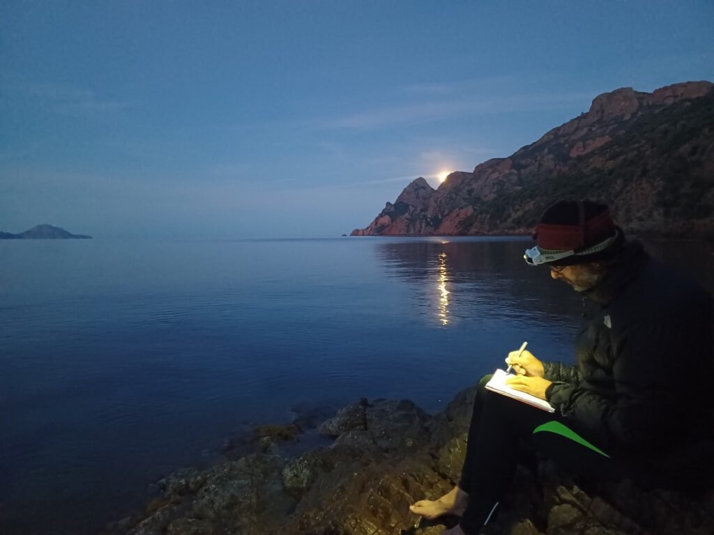 Pat resting on its night camp after a day sea kayaking in Corsica