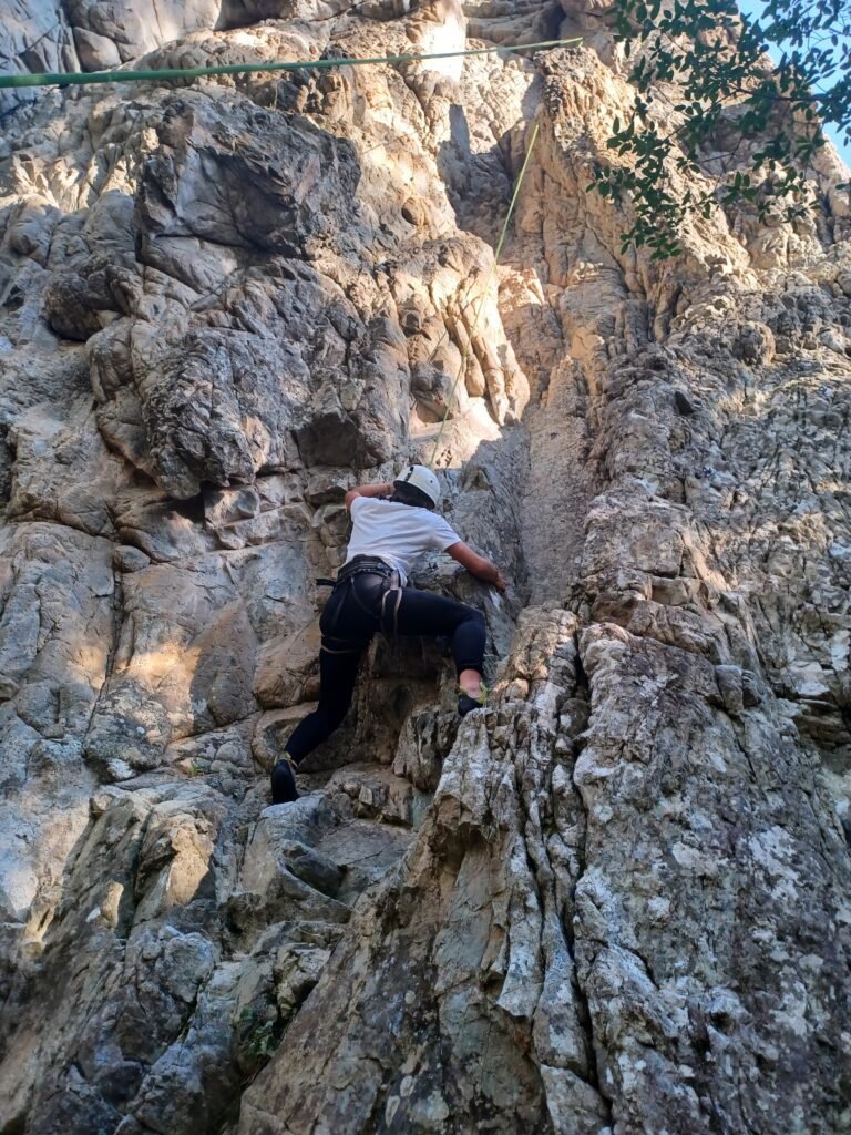 Jeune femme faisant de l'escalade sur falaise en Corse